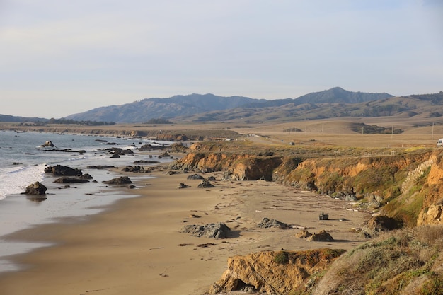 Photo a beach with a beach and mountains in the background