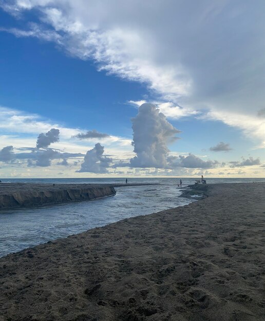 A beach with a blue sky and clouds