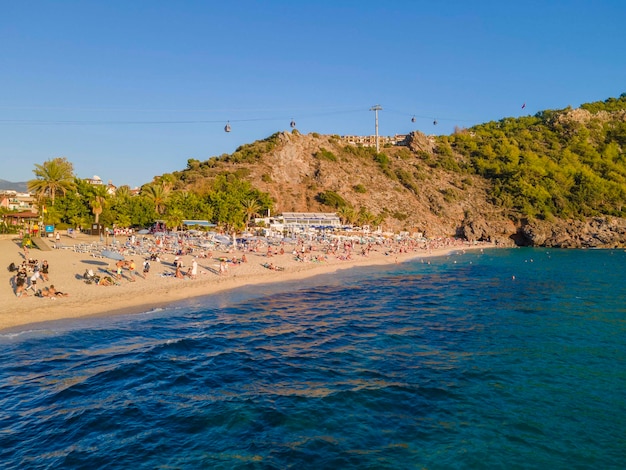 A beach with a blue sky and a hill in the background