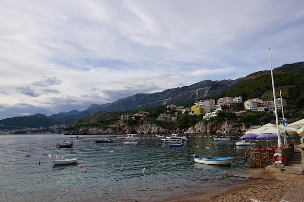 A beach with boats and mountains in the background