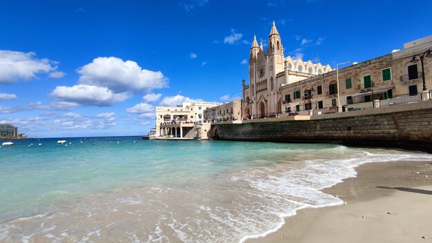 Photo a beach with a building in the background malta europe