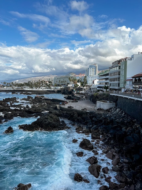 A beach with a building in the background and the ocean in the background