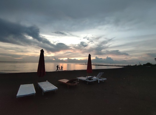 Photo a beach with a couple walking on it and a couple walking on the beach.