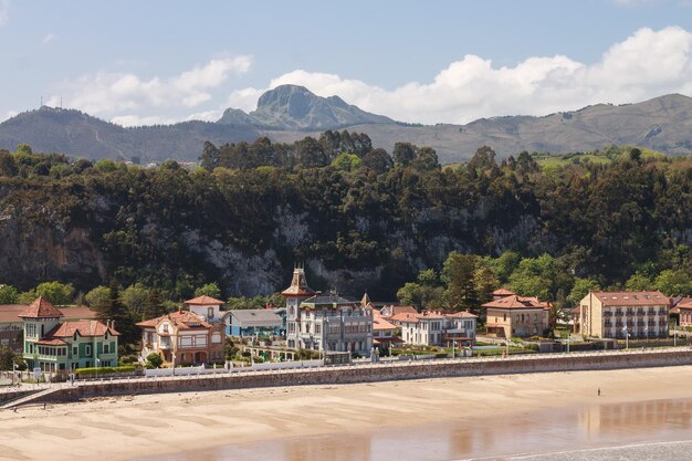 A beach with houses and trees in the background