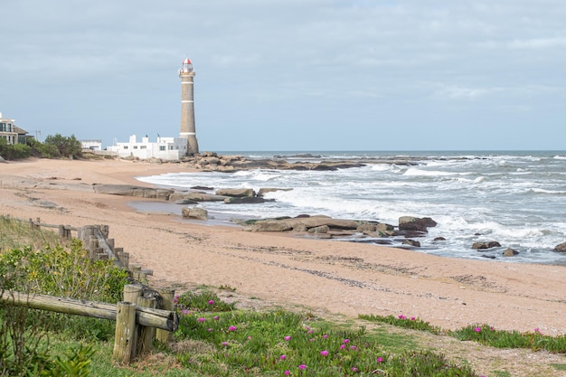 Foto una spiaggia con un faro sullo sfondo