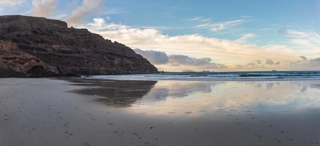 Photo a beach with a mountain in the background