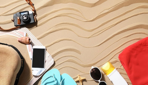 Foto una spiaggia con un telefono, una valigia, una bussola e una stella marina sulla sabbia.