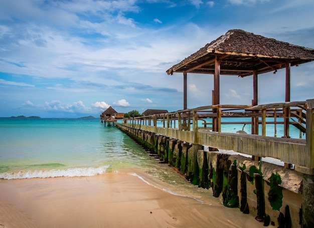 A beach with a pier and a building in the background