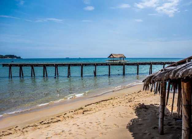 Photo a beach with a pier and a hut on it