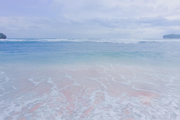 A beach with pink sand and blue water