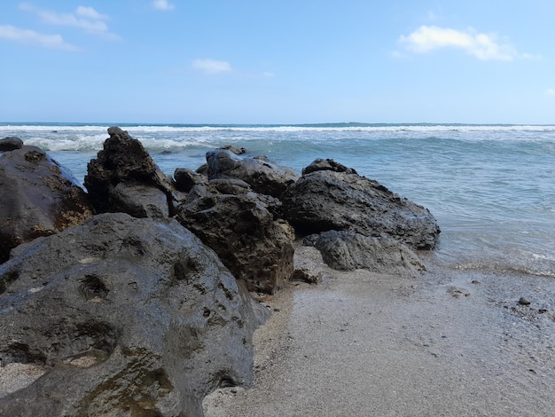 A beach with rocks and the ocean in the background