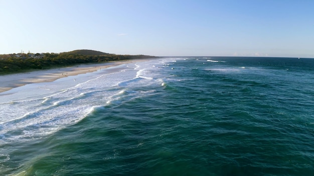 Photo a beach with a sandy beach and a blue sky