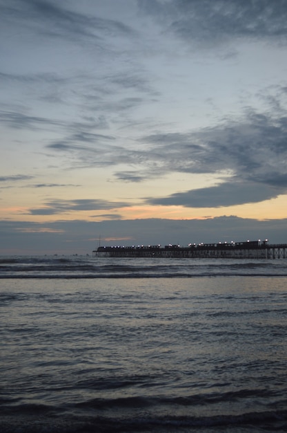 Spiaggia con mare e molo e persone