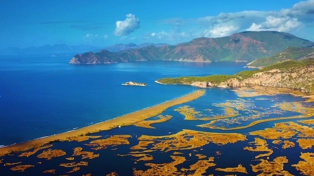 A beach with a sea view and mountains in the background