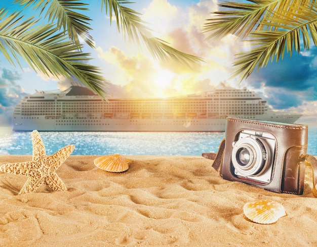 Photo beach with seashells starfish retro camera and a cruiseship