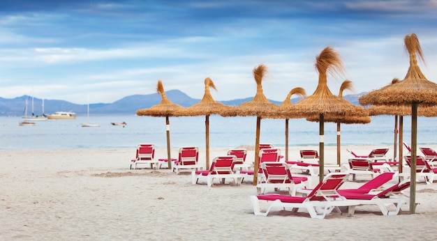 The beach with sunbeds and parasols of straw