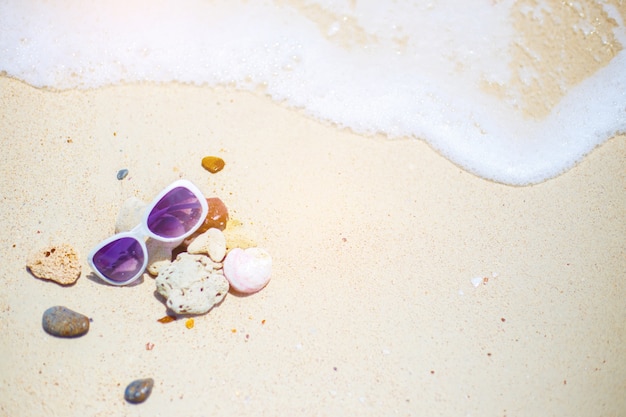 The beach with sunglasses on the rock