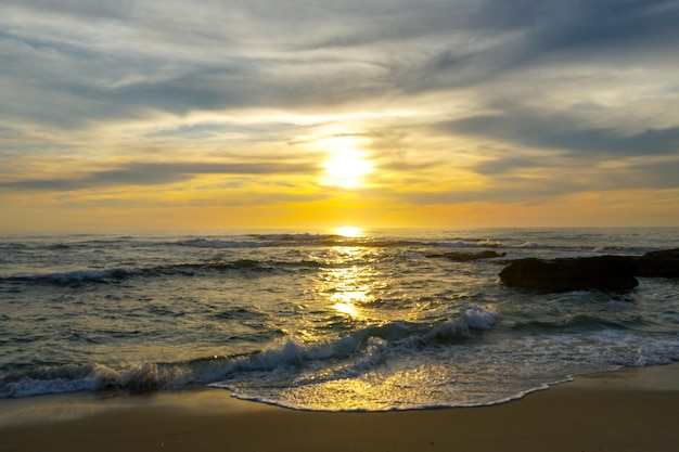 A beach with a sunset in the background