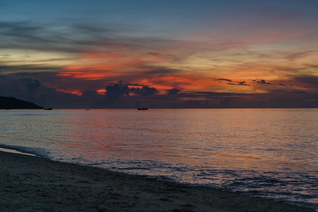 A beach with a sunset in the background