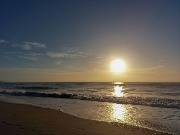 A beach with a sunset in the background