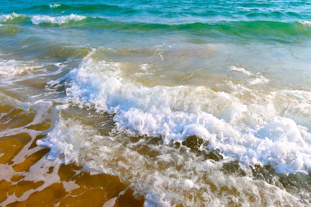 波と青い海の水の背景を持つビーチ