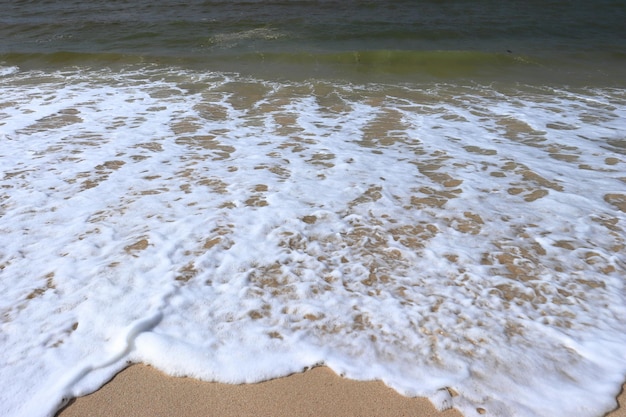 A beach with a wave crashing on it