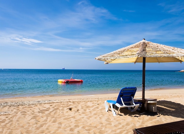 A beach with a yellow boat in the water