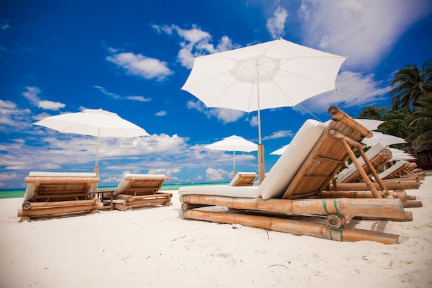 Tiri le sedie in legno in secco per le vacanze sulla spiaggia tropicale