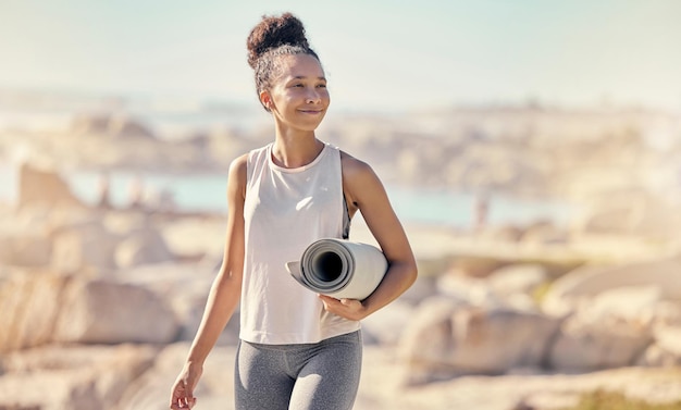 Photo beach yoga mat and black woman with smile outdoor for meditation wellness and peace to relax african american female lady and seaside walking health or pilates for exercise calm or seaside view