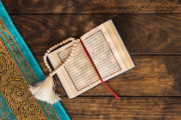 Beads and opened Quran near mat