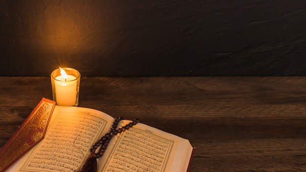 Beads on religious book near candle