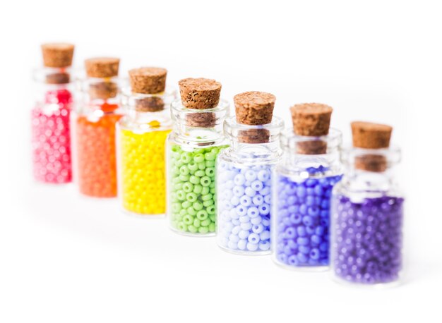 Beads in the vintage mini glass bottles with corks isolated on white