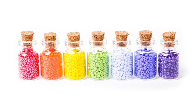 Beads in the vintage mini glass bottles with corks isolated on white