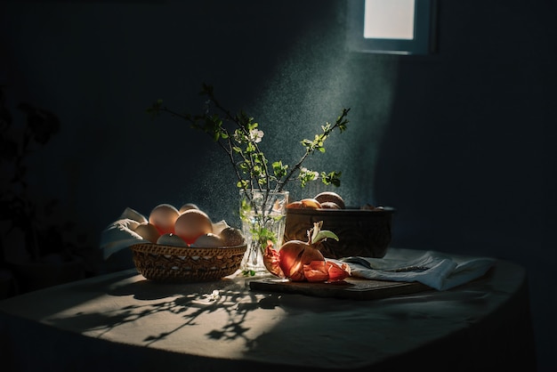 A beam of light from the window illuminates the table with food and flowers