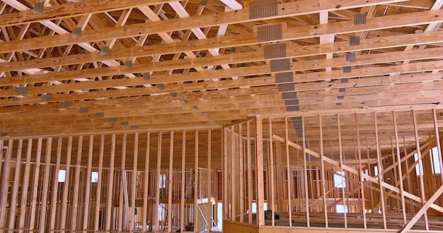Beams frame an interior view of a framed building construction of new wooden house