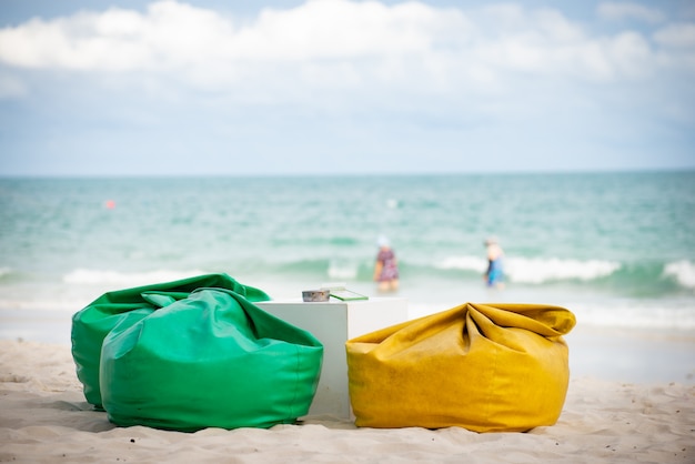 Foto poltrona a sacco o divano e tavolo per ristorante sulla spiaggia