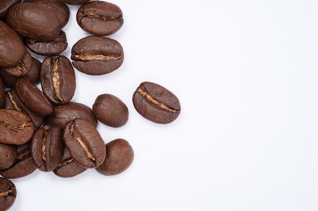 Bean coffee in white background. Medium roasted coffee beans are light brown in color in white background with copy space.