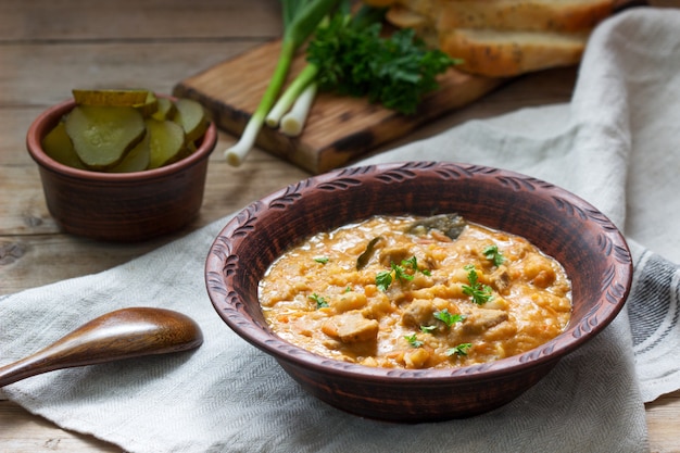 Bean and meat stew, served with pickles, bread and garlic. Rustic style.