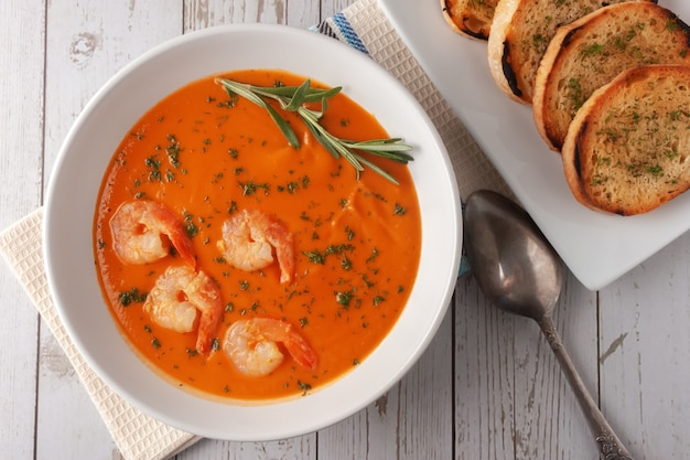 Bean puree soup with shrimp, tomatoes and rosemary.