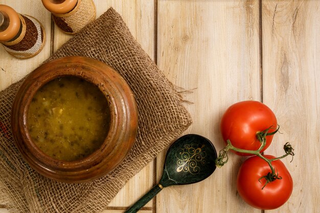 Bean soup in a traditional pot on a wooden floor. 