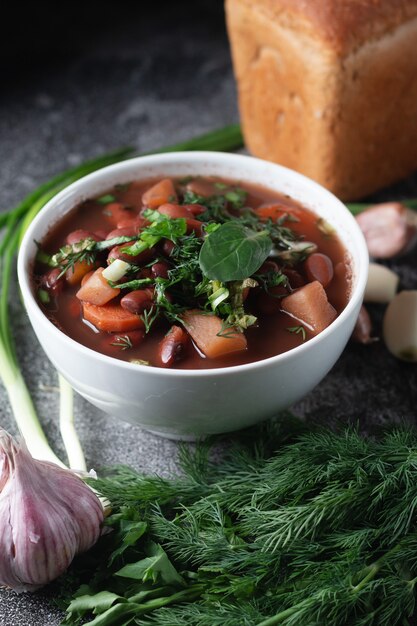 Bean soup with herbs in a white bowl 