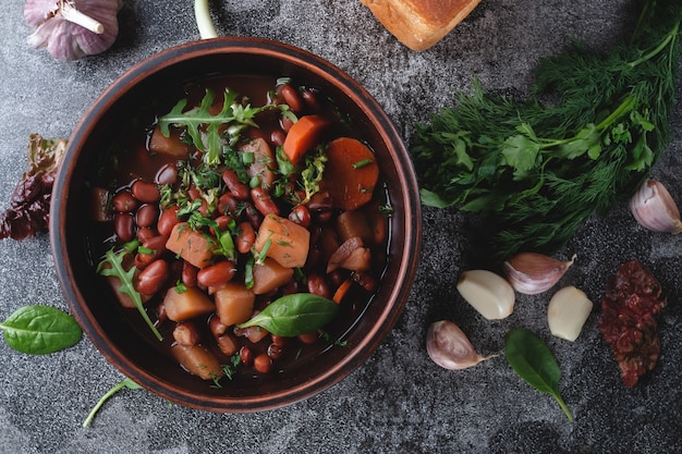 Bean soup with herbs in a white bowl