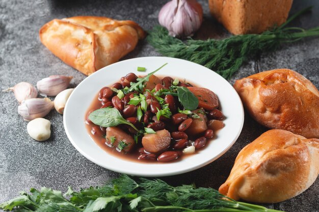 Bean soup with herbs in a white bowl 