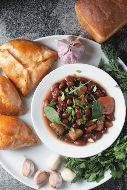 Bean soup with herbs in a white bowl 