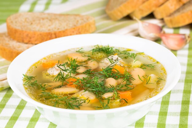 Bean soup with meatballs vegetables and dill