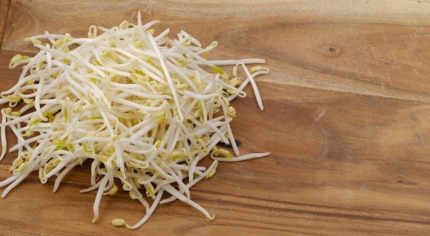 Bean sprouts on a wooden chopping board.