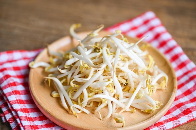 Photo bean sprouts on wooden plate table background in the kitchen raw white organic bean sprouts or mung bean sprout for food vegan