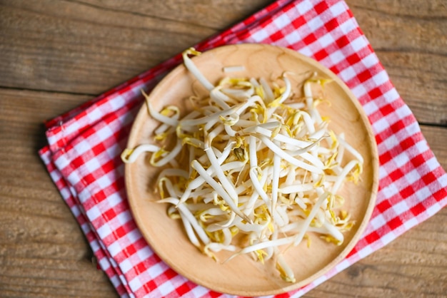 Bean sprouts on wooden plate table background in the kitchen Raw white organic bean sprouts or mung bean sprout for food vegan