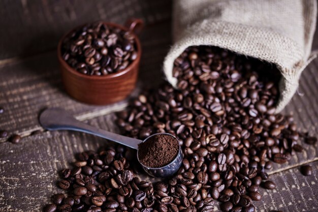 Beans of coffee and jute bag on wooden table