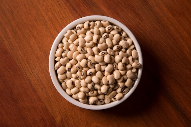 beans into a bowl on wooden table